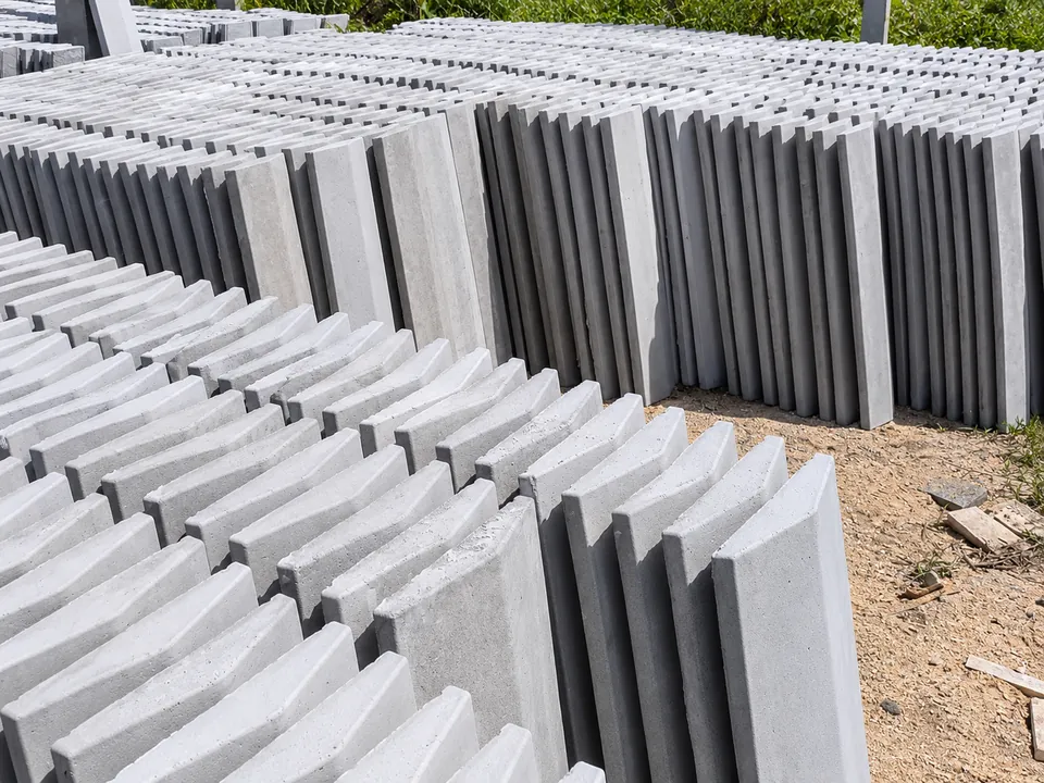 Pingadeiras de concreto empilhadas em pé no estoque da fábrica